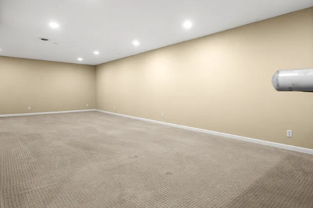 an empty room with a wooden floor and windows