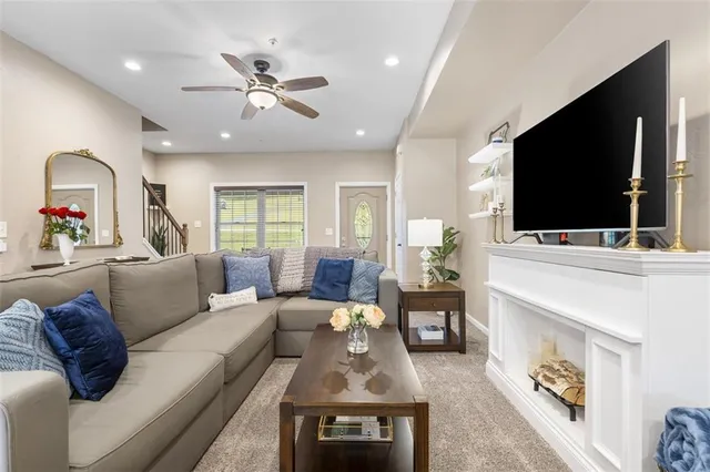 a living room with furniture a ceiling fan and a window