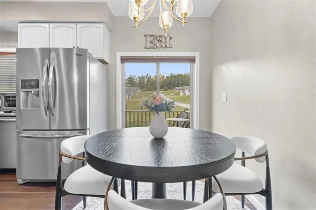 a kitchen with stainless steel appliances kitchen island a table and chairs