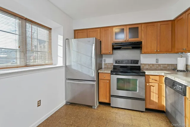 a kitchen with granite countertop a stove top oven and cabinets