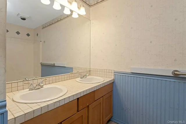 a bathroom with a double vanity sink and a mirror