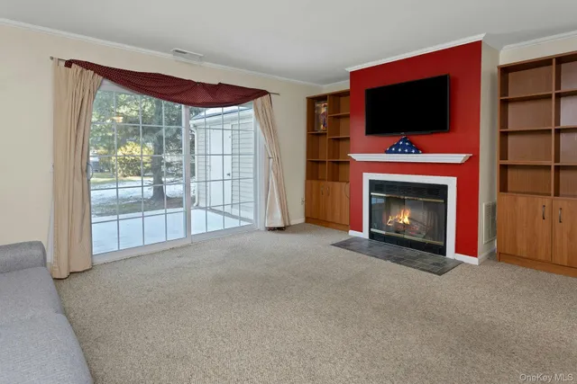 a view of empty room with furniture fireplace and window