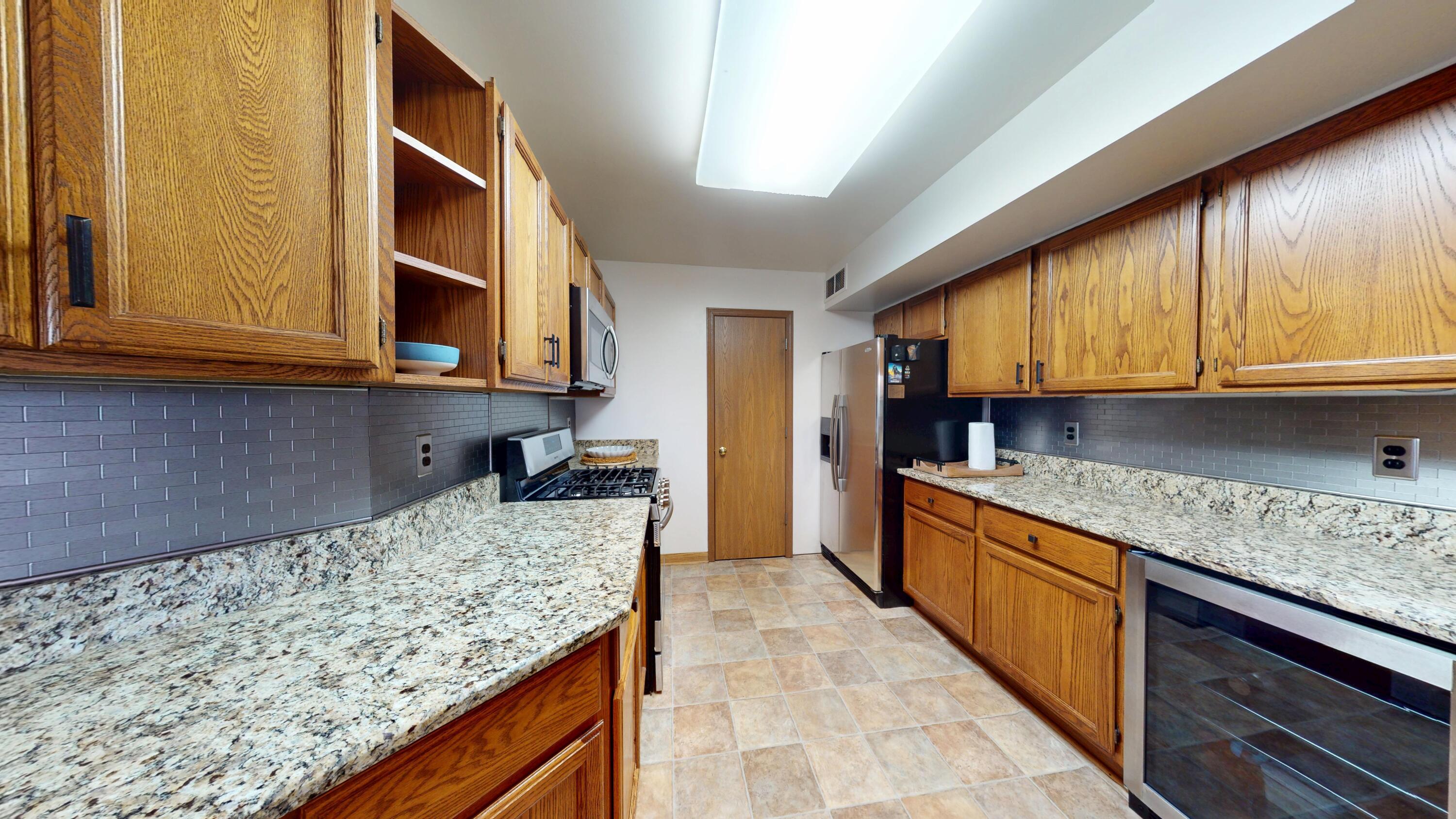 9344 Van Buren Street Crown Point, IN 46307 - Photo 12 of 37 a kitchen with granite countertop wooden cabinets and a sink