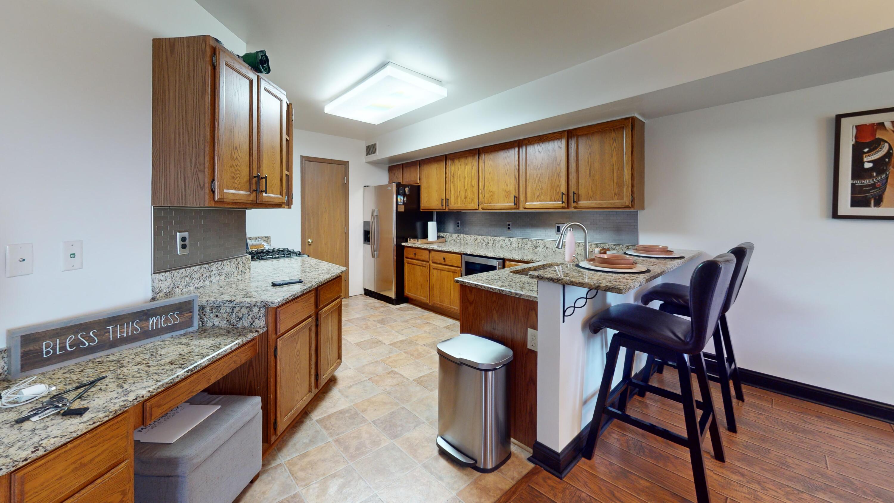 9344 Van Buren Street Crown Point, IN 46307 - Photo 10 of 37 a kitchen with stainless steel appliances granite countertop a stove a sink and a refrigerator