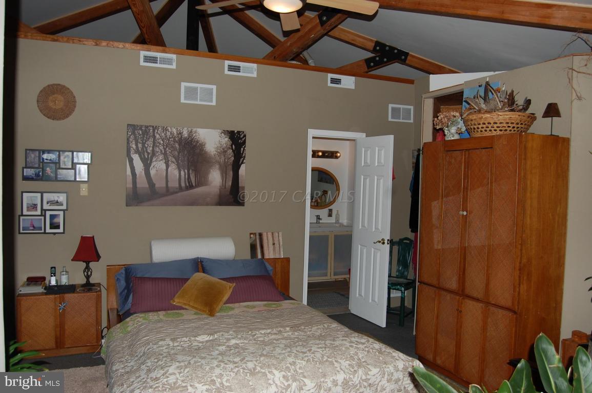10770 Harrison Point Road Deal Island, MD 21821 - Photo 16 of 29 a bedroom with bed and a refrigerator