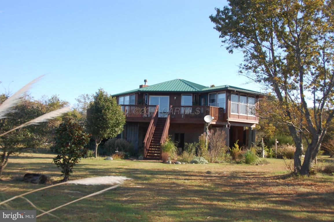 10770 Harrison Point Road Deal Island, MD 21821 - Photo 24 of 29 a view of a house next to a yard with large trees