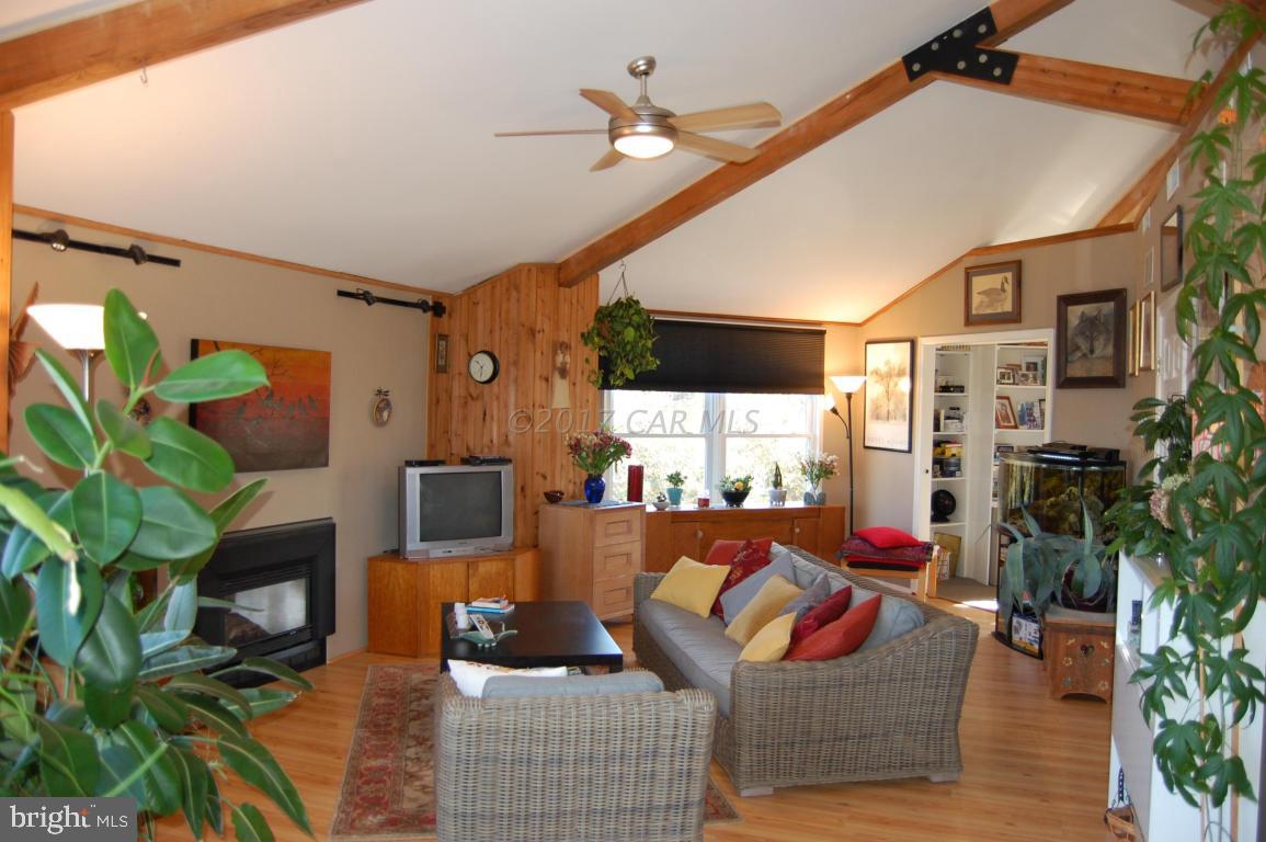 10770 Harrison Point Road Deal Island, MD 21821 - Photo 6 of 29 a living room with furniture a chandelier and a flat screen tv