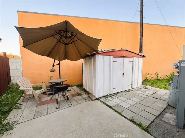 a view of a patio with a table and chairs under an umbrella