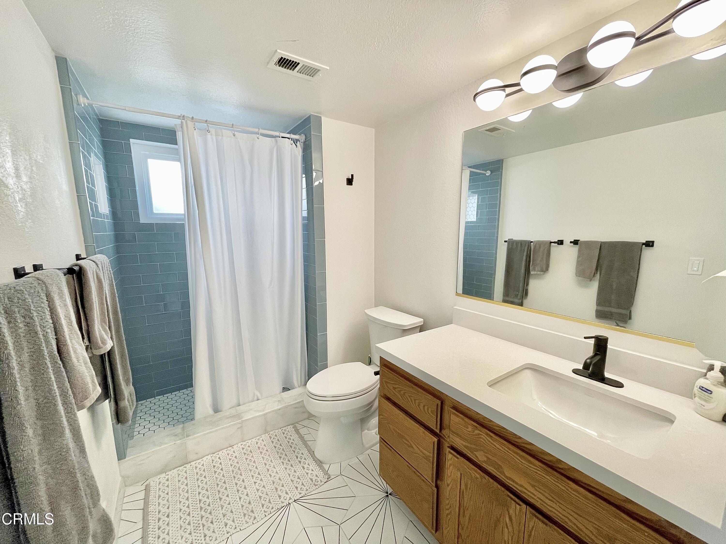 361 Rossmore Drive Oxnard, CA 93035 - Photo 25 of 26 a bathroom with a sink a toilet and a mirror