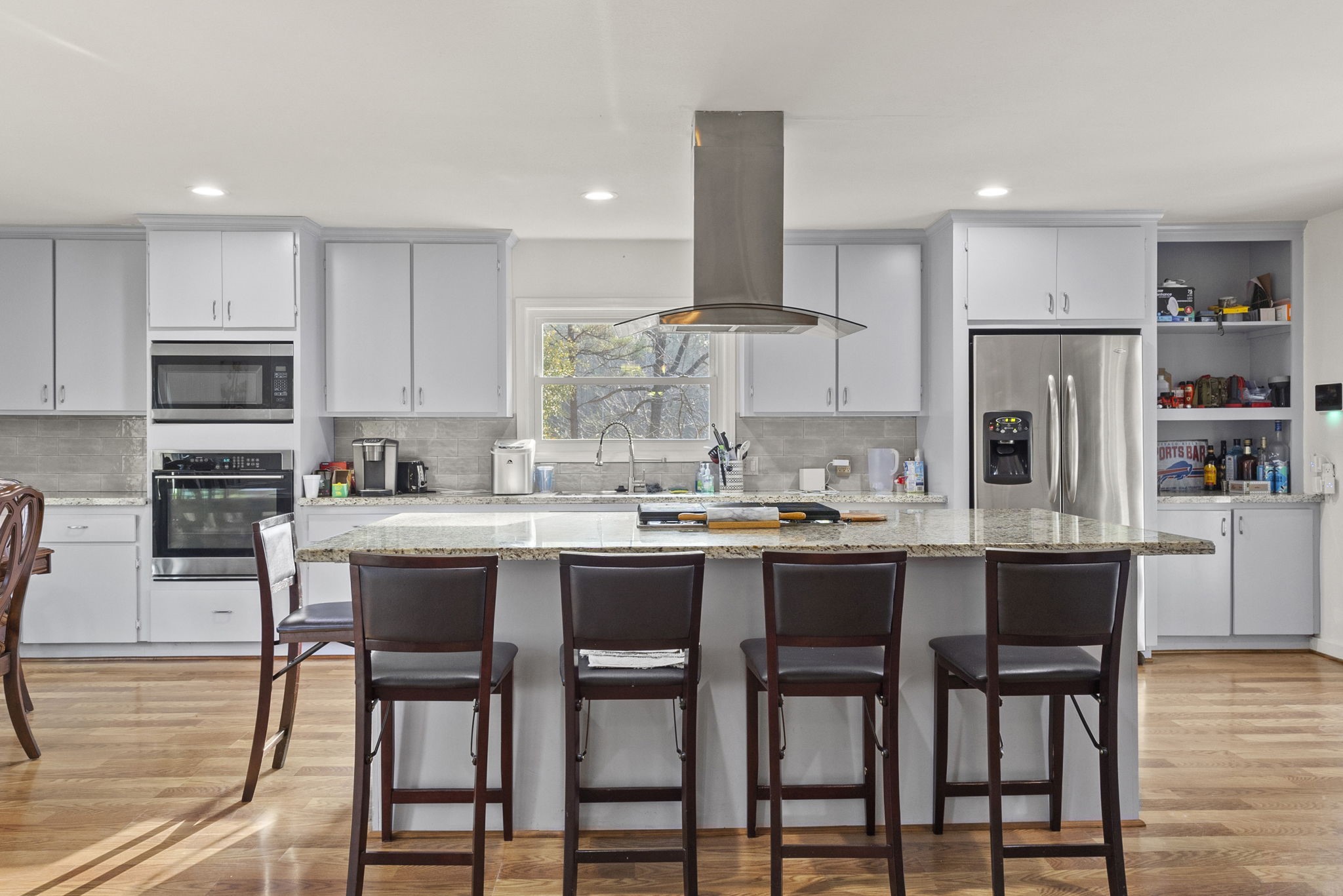 12498 Highway 69 Colmesneil, TX 75938 - Photo 11 of 50 a kitchen with stainless steel appliances granite countertop a dining table chairs refrigerator and microwave
