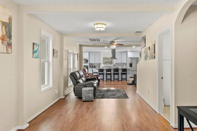 a living room with stainless steel appliances furniture and a kitchen view
