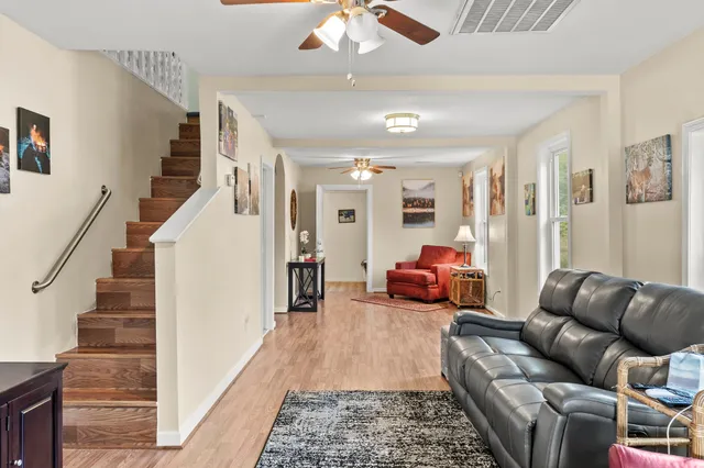 a living room with furniture ceiling fan and a rug