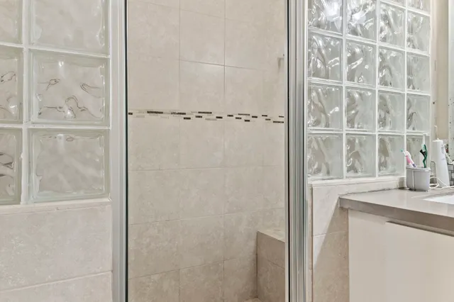 a bathroom with a granite countertop shower and a sink