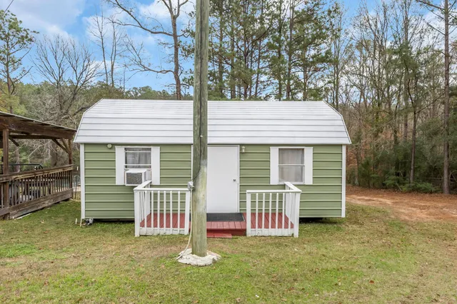 a view of a house with a yard and wooden fence