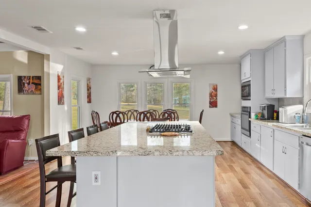 a kitchen with kitchen island granite countertop a table and chairs