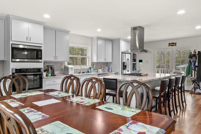 a dinning room and kitchen with a table chairs a workspace