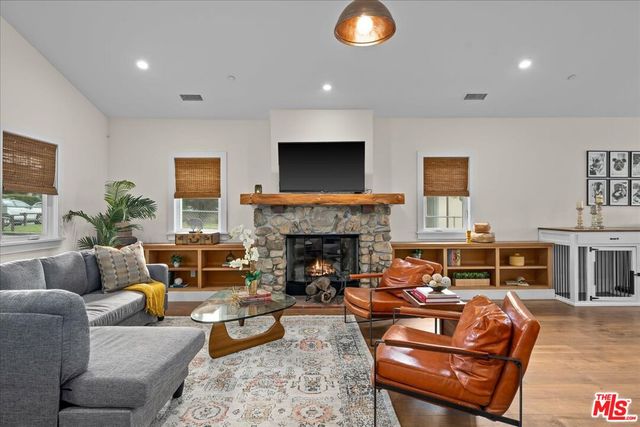 a living room with furniture a fireplace and a flat screen tv