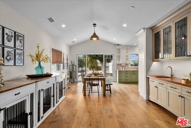 a kitchen that has a lot of cabinets a sink and appliances in it