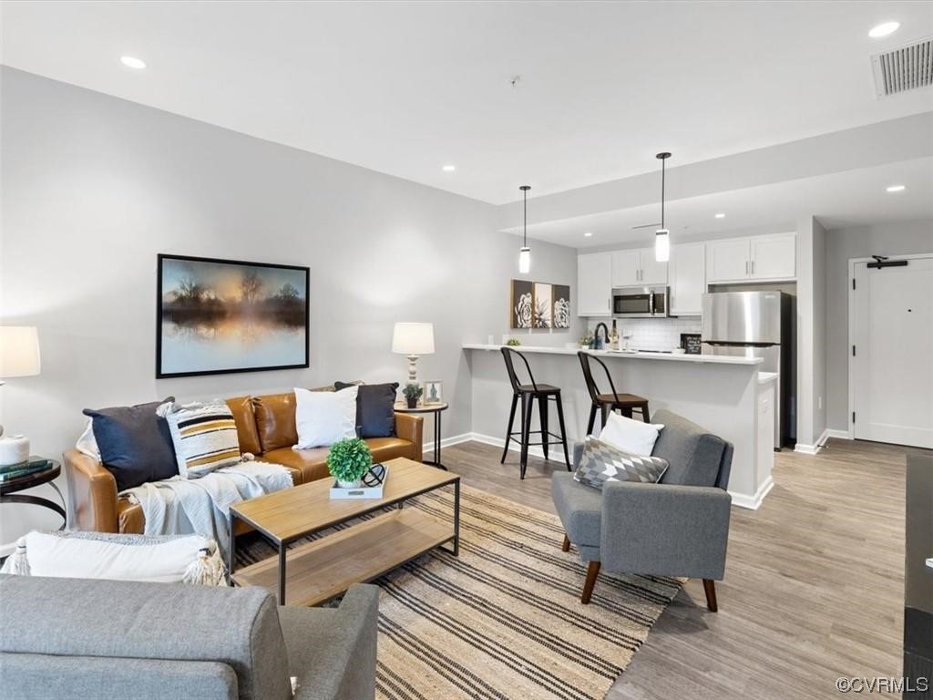 a living room with furniture and view of kitchen