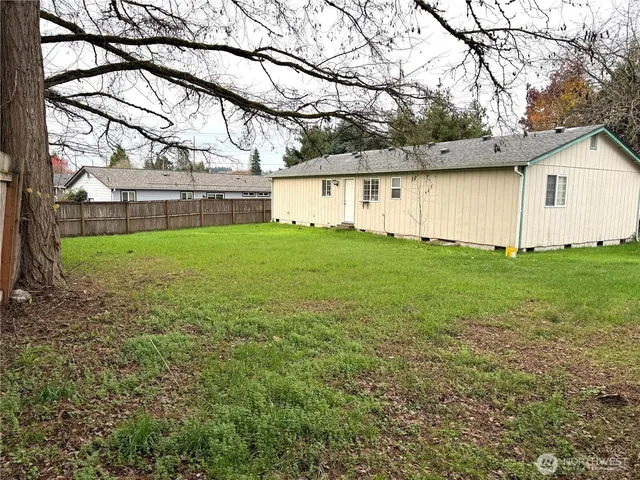 a view of a yard with a house and a large tree