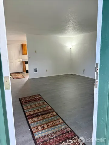 an empty room with wooden floor cabinet and windows