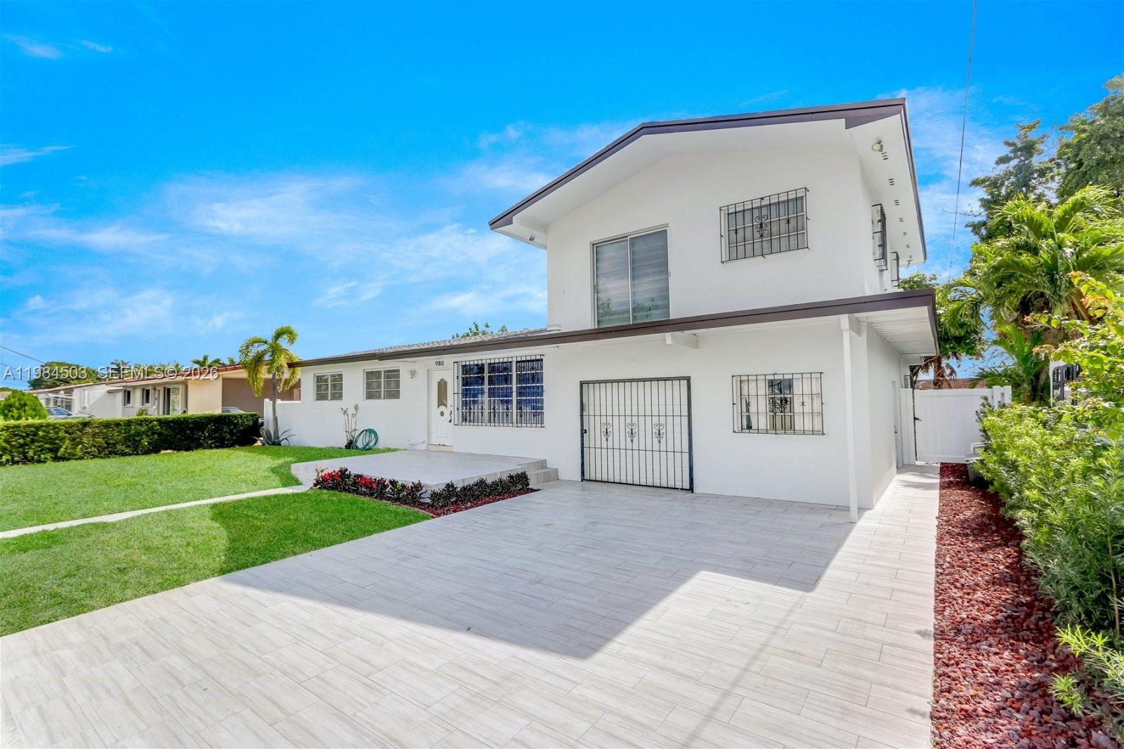 980 West 45th Place, Unit 2 Hialeah, FL 33012 - Photo 2 of 13 a front view of a house with a yard and garage