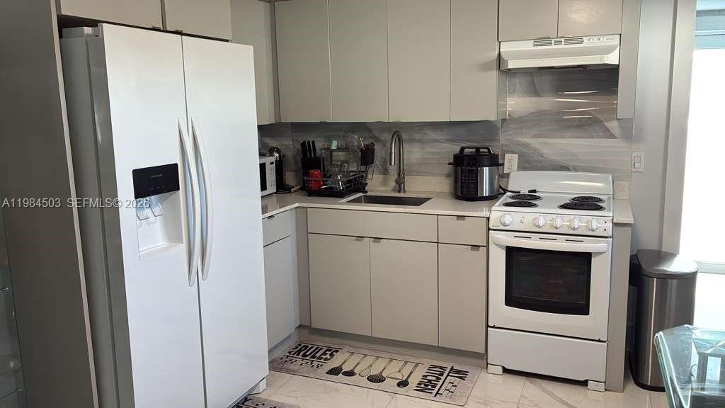 980 West 45th Place, Unit 2 Hialeah, FL 33012 - Photo 4 of 13 a kitchen with a refrigerator sink stove and cabinets