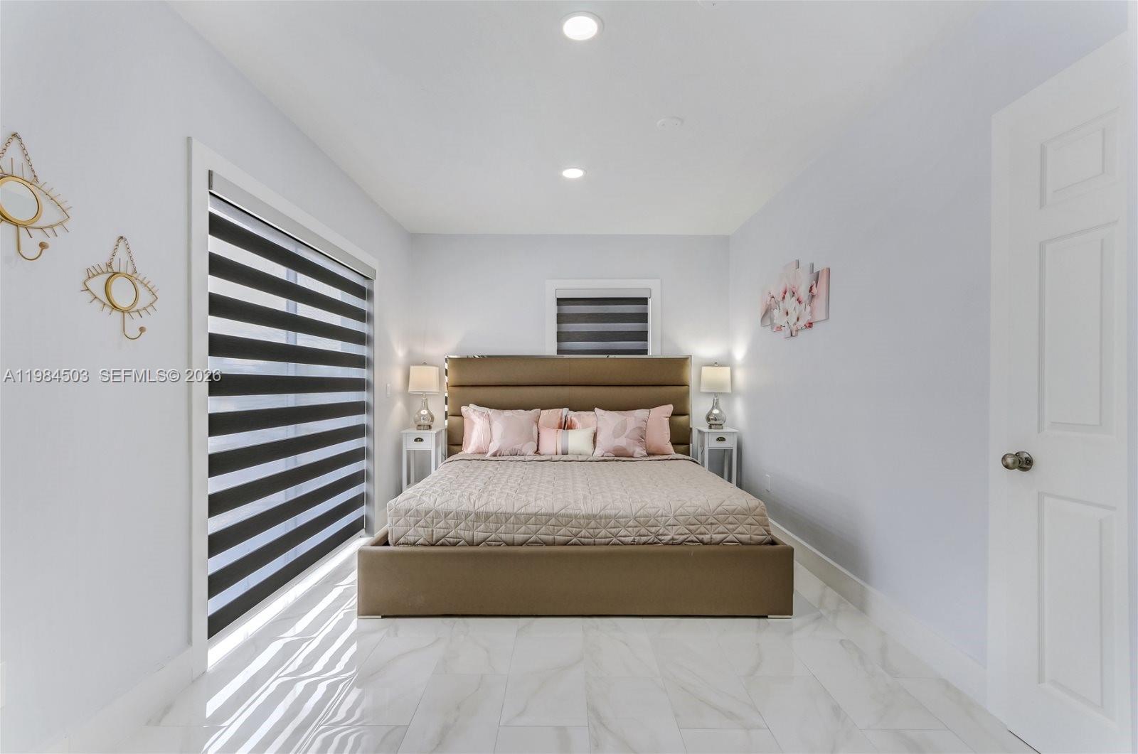 980 West 45th Place, Unit 2 Hialeah, FL 33012 - Photo 6 of 13 a spacious bedroom with a bed and a chandelier
