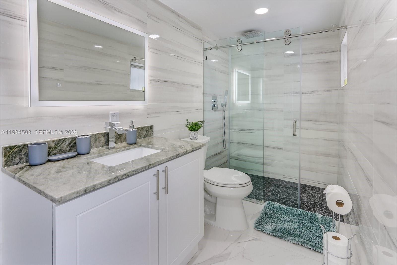 980 West 45th Place, Unit 2 Hialeah, FL 33012 - Photo 8 of 13 a bathroom with a granite countertop sink a toilet and shower