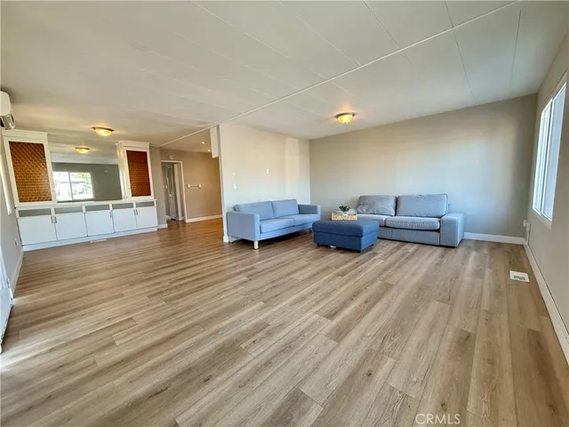 a room with wooden floor pool table and windows