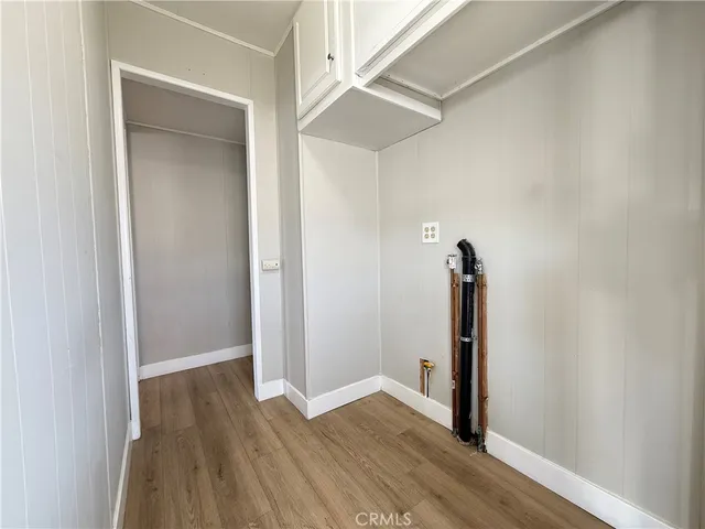a kitchen with wooden floors and white cabinets