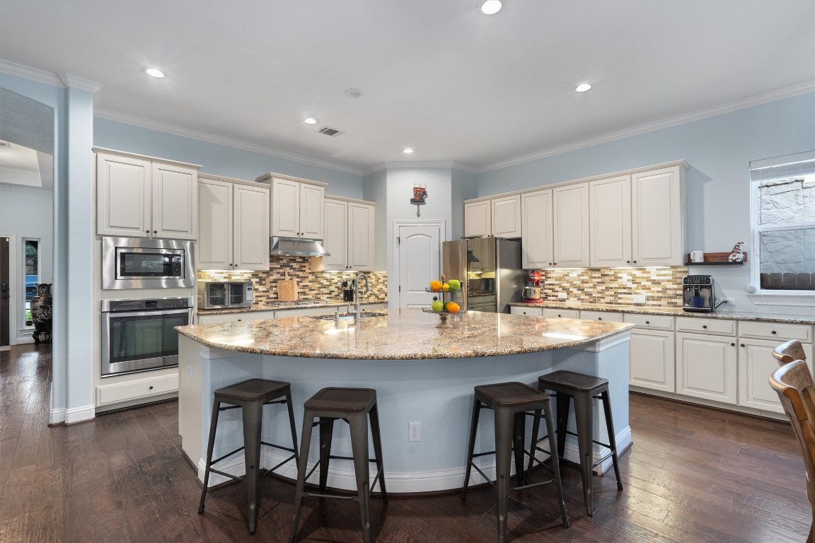 2734 Grand Oaks Loop Cedar Park, TX 78613 - Photo 1 of 1 a kitchen with stainless steel appliances granite countertop white cabinets and chairs