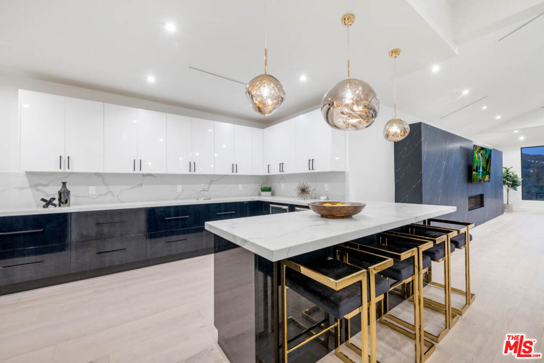 2990 Lakeridge Drive Los Angeles, CA 90068 - Photo 15 of 53 a kitchen with a table chairs and a clock on the wall