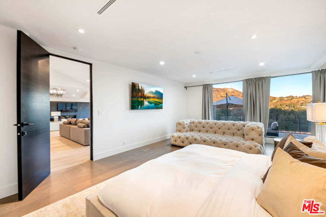 2990 Lakeridge Drive Los Angeles, CA 90068 - Photo 21 of 53 a bedroom with a bed and a large window
