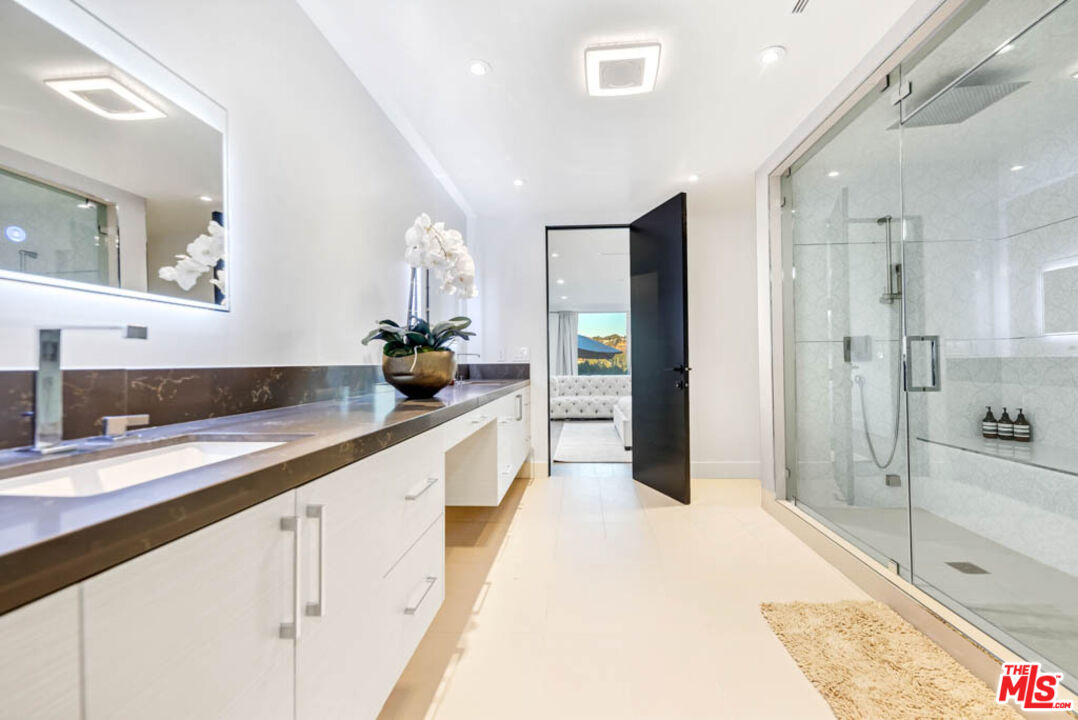 2990 Lakeridge Drive Los Angeles, CA 90068 - Photo 28 of 53 a large bathroom with a double vanity sink a large mirror a shower and bathtub