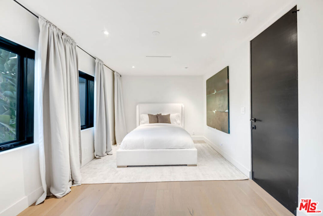 2990 Lakeridge Drive Los Angeles, CA 90068 - Photo 32 of 53 a bedroom with a large bed and a large mirror