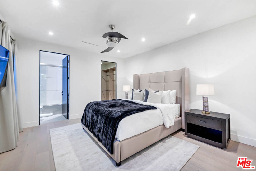 2990 Lakeridge Drive Los Angeles, CA 90068 - Photo 38 of 53 a spacious bedroom with a bed and a chandelier