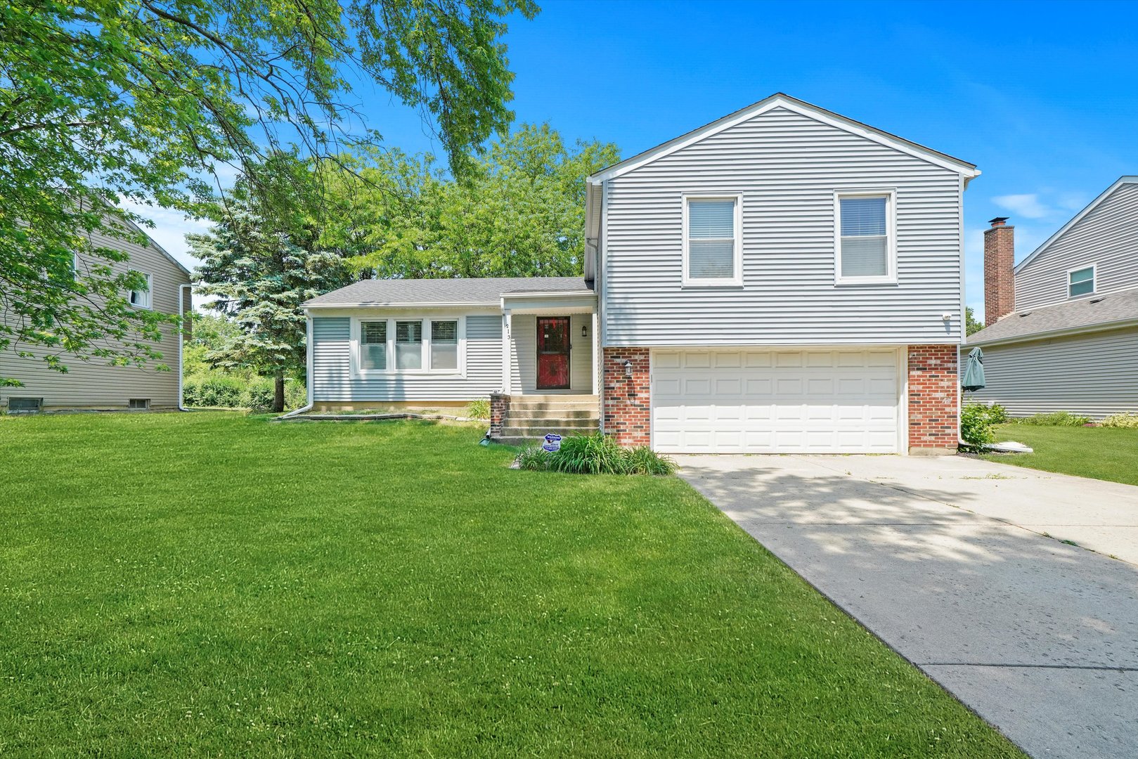 a front view of a house with a yard and trees