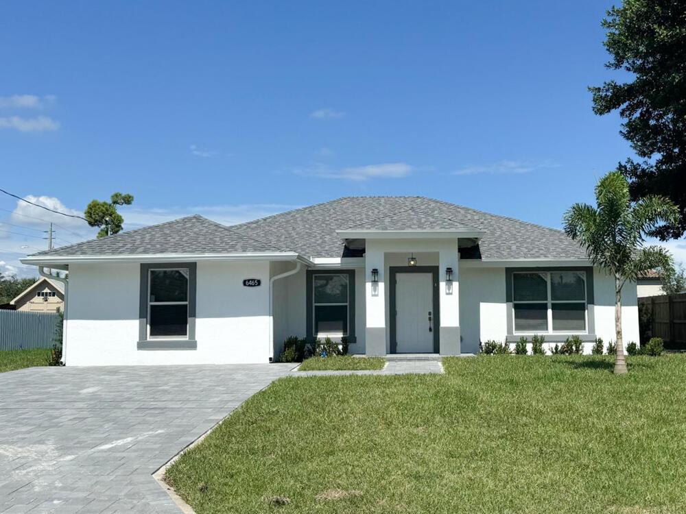 6465 Alexander Road West Palm Beach, FL 33413 - Photo 2 of 20 a front view of a house with a yard and garage
