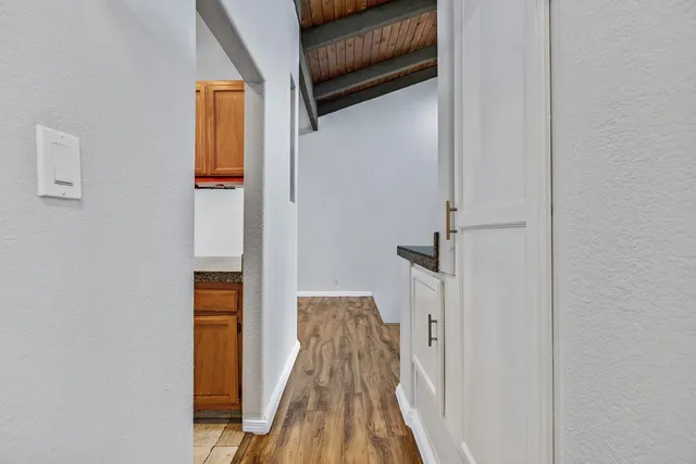 a view of a hallway with wooden floor and staircase
