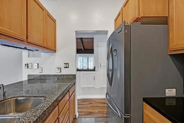 a kitchen with stainless steel appliances granite countertop a sink and a refrigerator
