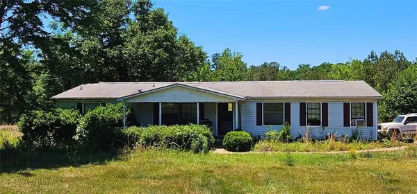 a view of a house with a yard and potted plants