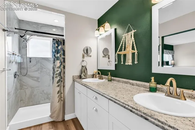 a bathroom with a granite countertop sink vanity mirror and shower