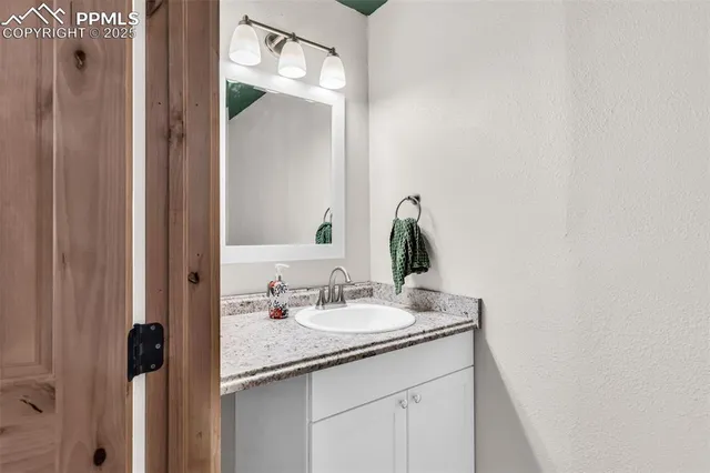 a bathroom with a granite countertop sink and a mirror