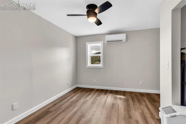 an empty room with a window and a ceiling fan