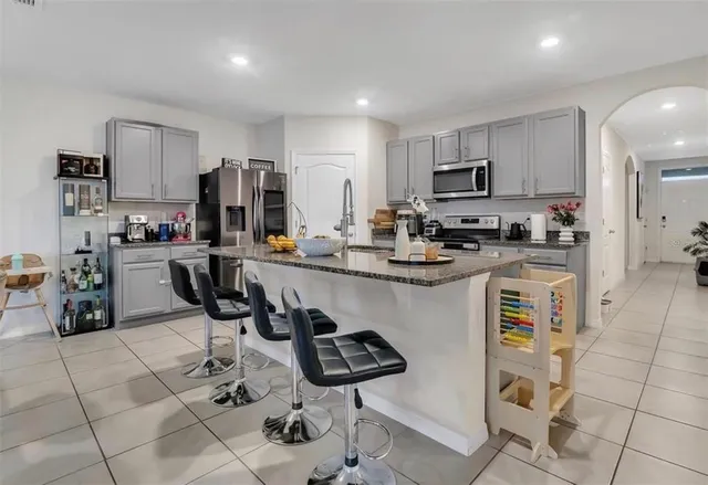 a kitchen with stainless steel appliances kitchen island granite countertop a sink and cabinets