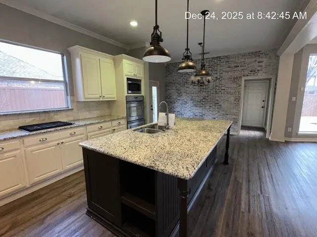 a kitchen with a center island wooden floor and a chandelier