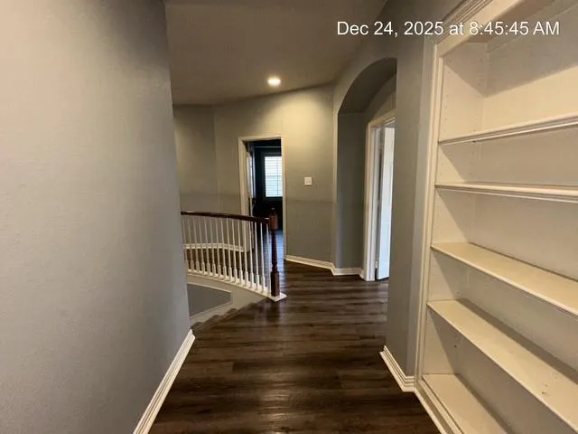 a view of a hallway with wooden floor and staircase