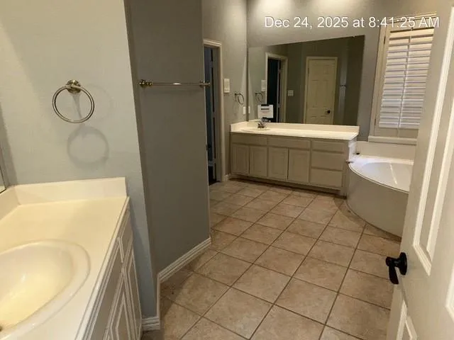 a bathroom with a bathtub sink and mirror