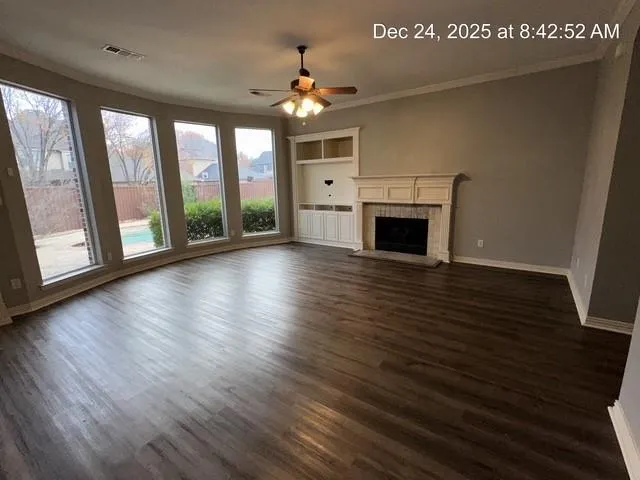 a view of a livingroom with wooden floor a fireplace and window
